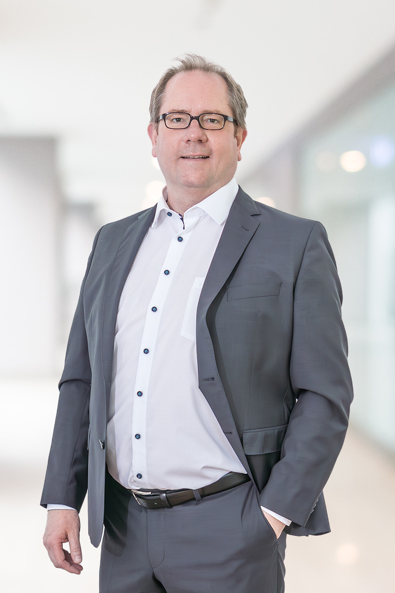 Dr. Marcus Schneider: Ein professionelles, aber nahbares Foto. Kein steifer Anzug, eher Hemd/hochgekrempelte Ärmel oder dezentes T-Shirt unter Sakko. Blickkontakt. Er strahlt „Macher-Kompetenz“ aus.